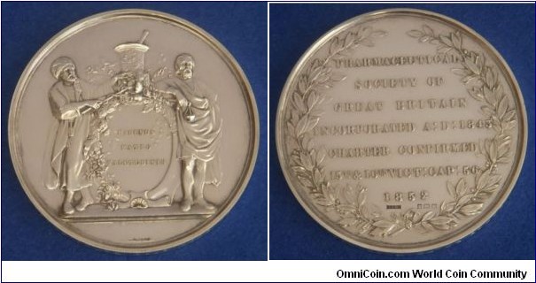 1852 UK Pharmaceutical Society of Great Britian Medal by Leonard Charles Wyon.  Silver: 70MM./163 gms.
Obv: The Coat of Arms of the society supported by a figure in Eastern garb & another in antique garb. Rev: Inscription of 7 lines within a wreath. Hallmarks for Birmingham 1931. Edge: engraved recipient details, HORACE ROLFE, PHARMACOGNOSY, 1931.
