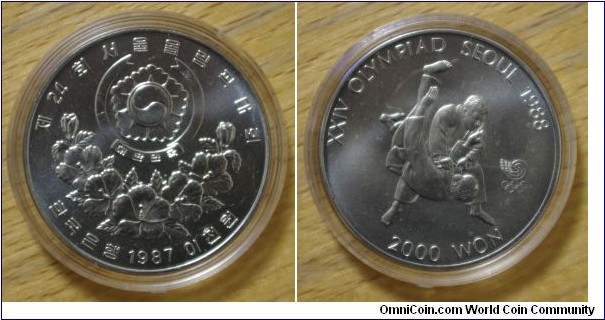 South Korea | 
2,000 Won, 1987 - Taekwondo | 
33 mm, 17 gr. | 
Nickel | 

Obverse: National Coat of Arms and above floral spray, date and denomination below | 
Lettering: 제24회서울올림픽대회 한국은행 1987 이천원 | 

Reverse: Taekwondo practitioners, denomination below | 
Lettering: XXIV OLYMPIAD SEOUL 1988 2000 WON |