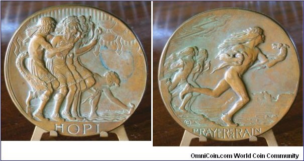 1931 SOM #3 Issue, Hopi Prayer For Rain Oval Medal by H.A.MacNeil. Bronze: 70 X 73MM
Obv: 5 Hopi Indian dancers enacing the prayer for rain, 2 with venomous snakes in their mouths, under stylized clouds, reminiscent of Native sand art printing. H.A MacNeil inscribed on the bottom right. Rev: A dynamic design of dancers running to return the snakes to their dens as the lightning and rain begin.
