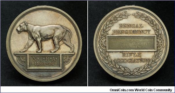 1886 British India, Bengal Presidency Army Rifle Association Medal by Pinches. Silver: 54MM/90.45 gm.
Obv: Indian Lioness on a plinth advancing left. Inscribed table below. Legend.N.I.R.A./1863-86. Rev: Engraved table within wreath. Engraving 'Band Sergt R.A. McAlister/2nd Royal Sussez Regt