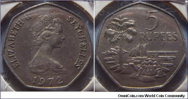 Seychelles |  
5 Rupees, 1972 | 
30 mm, 13.5 gr. | 
Copper-nickel

Obverse: Queen Elizabeth II facing right, date below | 
Lettering: ELIZABETH II SEYCHELLES 1972 | 

Reverse: Palm tree and turtle, ship at sea, denomination right | 
Lettering: 5 RUPEES |