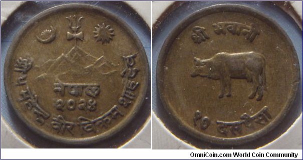 Nepal | 
10 Paisa, 1967 (2024) | 
21 mm, 4 gr. | 
Brass | 

Obverse: Trident with sun and moon flanking above hills, date below | 
Lettering: नेपाल २०२४ श्री ५ महेन्द्र वीर विक्रम शाहदेव | 

Reverse: Ox facing left, denomination below | 
Lettering: श्री भवानी १० दस पैसा |