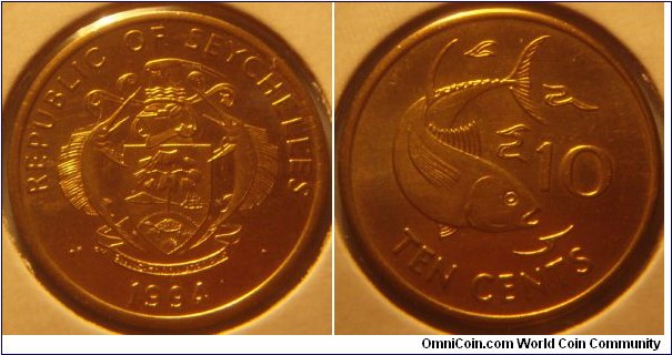 Seychelles | 
10 Cents, 1994 |   
21mm, 3.34 gr. | 
Brass | 

Obverse: National Coat of Arms, date below | 
Lettering: REPUBLIC OF SEYCHELLES • 1994 • | 

Reverse: Tuna fish, denomination below | 
Lettering: TEN CENTS |