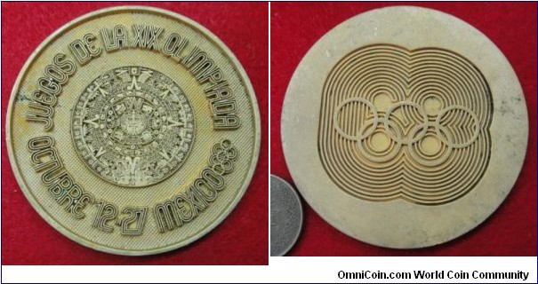 1968 Mexico Olympic Game Medal stamped in Spanish Lauguage. Gilted Bronze: 53MM./34.8 gm.
Obv: Legend JUEGOS DE LA XIX OLIMPIADA OCTUBRE 12-27 MEXICO Olympic rings. Aztec calture symbol in centre. Rev: Olympic Rings with figure 68 in art formet. 

