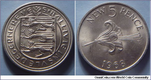 Guernsey | 
5 New Pence, 1968 | 
23.6 mm, 5.65 gr. | 
Nordic Gold | 

Obverse: National Coat of Arms | 
Lettering: S'BALLVIE INSVLE DEGERNERE VE | 

Reverse: Guernsey Lily, denomination above, date below | 
Lettering: NEW 5 PENCE 1968 |