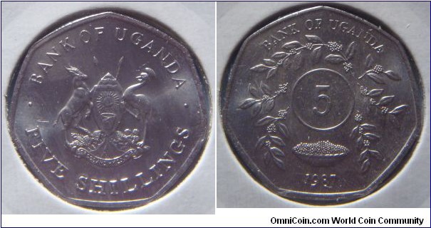 Uganda | 
5 Shillings, 1987 | 
22 mm, 3.5 gr. | 
Stainless Steel |  

Obverse: National Coat of Arms, denomination below | 
Lettering: • BANK OF UGANDA • FIVE SHILLINGS | 

Reverse: Circle of sprigs, denomination middle, date below | 
Lettering: BANK OF UGANDA 5 1987 |
