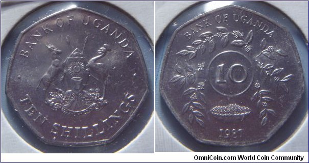 Uganda | 
10 Shillings, 1987 | 
26 mm, 5.7 gr. | 
Stainless Steel |  

Obverse: National Coat of Arms, denomination below | 
Lettering: • BANK OF UGANDA • TEN SHILLINGS | 

Reverse: Circle of sprigs, denomination middle, date below | 
Lettering: BANK OF UGANDA 10 1987 |