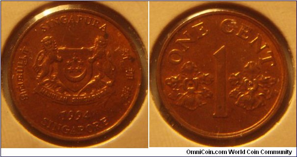 Singapore | 
1 Cent, 1994 | 
15.9 mm, 1.25 gr. | 
Copper plated Zinc | 

Obverse: National Coat of Arms with ribbons downwards, date below | 
Lettering: சிங்கப்பூர் SINGAPURA 新加坡 SINGAPORE 1994 | 

Reverse: Denomination flanked by two orchids 
