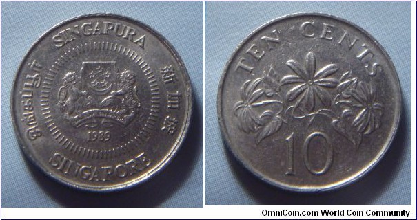 Singapore | 
10 Cent, 1989 | 
18.5 mm, 2.6 gr. | 
Copper-nickel | 

Obverse: National Coat of Arms with ribbons upwards, date below | 
Lettering: சிங்கப்பூர் SINGAPURA 新加坡 SINGAPORE 1989 | 

Reverse: The Star Jasmine, denomination below | 
Lettering: TEN CENTS 10 | 