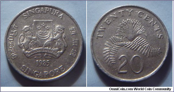 Singapore | 
20 Cent, 1985 | 
21.36 mm, 4.5 gr. | 
Copper-nickel | 

Obverse: National Coat of Arms with ribbons upwards, date below | 
Lettering: சிங்கப்பூர் SINGAPURA 新加坡 SINGAPORE 1987 | 

Reverse: Powder-puff Plant, denomination below | 
Lettering: TWENTY CENTS 20 |