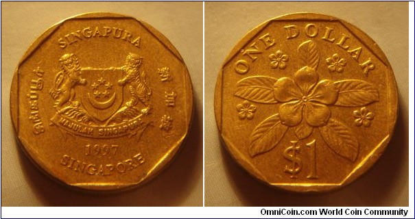 Singapore | 
1 Dollar, 1997 | 
22.4 mm, 6.3 gr. | 
Aluminium-bronze | 

Obverse: National Coat of Arms with ribbons downwards, date below | 
Lettering: சிங்கப்பூர் SINGAPURA 新加坡 SINGAPORE 1997 | 

Reverse: Periwinkle, denomination below | 
Lettering: ONE DOLLAR $1 |