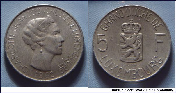 Luxembourg | 
5 Francs, 1962 | 
24 mm, 6 gr. | 
Copper-nickel | 

Obverse: Charlotte, Grand Duchess of Luxembourg facing right, date below | 
Lettering: CHARLOTTE GRANDE-DUCHESSE DE LUXEMBOURG 1962 |

Reverse: National Coat of Arms divides denmoniation | 
Lettering: GRAND-DUCHE DE LUXEMBOURG 5 F |