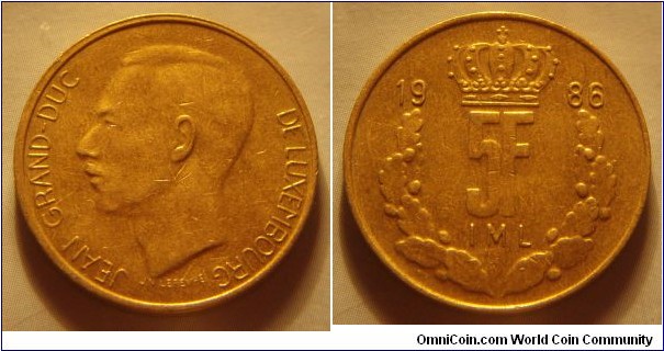 Luxembourg | 
5 Francs, 1986 | 
24 mm, 5.5 gr. | 
Aluminium-bronze | 

Obverse: Jean, Grand Duke of Luxembourg facing left | 
Lettering: JEAN GRANDE-DUC DE LUXEMBOURG |

Reverse: Crown divides date, denmoniation within wreath below | 
Lettering: 1986 5F |