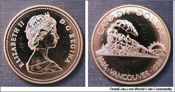 1986 Canada Silver Dollar Proof, Vancouver Centennial. 100th anniversary of the founding of Vancouver and the arrival of the first trans-Canada train in Vancouver.  Canadian Pacific Engine No. 371 was the first to arrive in 1886.  mintage 496,418 .925 Silver, 25.17g, 36mm, Reeded edge.
