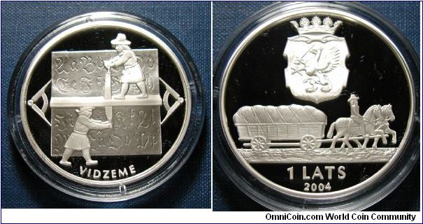 2004 Latvia 1 Lats, Vidzeme, econd in the three-coin series named Time.  Vidzeme is the northern province of Latvia, covering the area from Riga - the capital - to the border of Estonia. Sigulda, Cesis and Valmiera are among the historical small towns situated in the area, and Gauja, the longest river in Latvia, also flows through the province. Nowhere in Latvia have the wars of the 17th and 18th centuries left such devastation as in Vidzeme, where entire parishes remained abandoned as a result