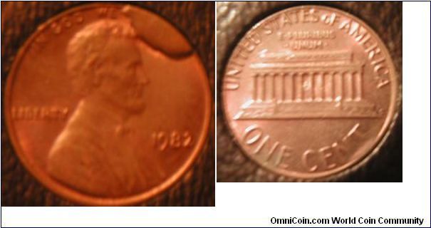 Error:

1982 Lincoln cent. This coin was struck with a die that had a large chip or die break at 2 o'clock, completely obscuring the word 'TRUST'. The error is also known as a 'cud'.

I believe this was either found in a roll or in change several years ago.

The pictures are not the actual color of the coin, but show the detail well.
