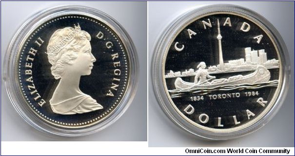 Silver Dollar.
Celebrates Toronto's sesquicentennial (150 years.)Reverse features a lone indian in a canoe against the Toronto skyline.