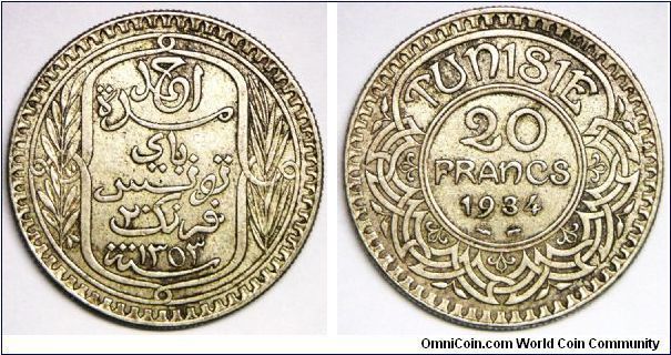 French Protectorate (1881-1955), Ahmad Pasha Bey (1929-1942), Decimal coinage, 20 Francs, AH1353/1934a. 20g, 0.6800 Silver, .4372 Oz. ASW. Obv.: Inscription within oblong design flanked by sprigs. Obv. Legend: AHMAD. Rev.: Value and date within center circle of design. Mint: Paris. Mintage: 9,500 units (perhaps slightly more than this figure). VF+ to EF. Scarce. This coin is undervalued in Krause.