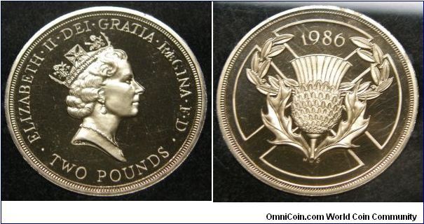 13th Commonwealth Games, held in Scotland.
Obverse;head of Queen ELIZABETH II DEI GRATIA REGINA F D TWO POUNDS.
 Reverse: Thistle on St Andrew's Cross, 1986 above. 
Edge inscription: XIII COMMONWEALTH GAMES SCOTLAND 1986. 1986 Proof Set.